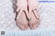 A woman's feet with a ring on her finger.