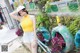 A woman in a yellow tank top and white shorts posing next to a bike.