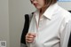 A woman in a white shirt sitting at a desk.