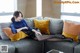 A woman sitting on a couch with her legs crossed.