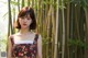 A woman standing in front of a bamboo forest.