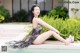 A woman sitting on the edge of a swimming pool.