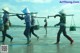 A group of people walking across a body of water.