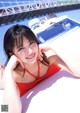 A woman in a red bathing suit laying on a boat.