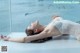 A woman laying on the floor in a white lingerie.