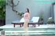 A woman in a pink bikini standing in a pool.